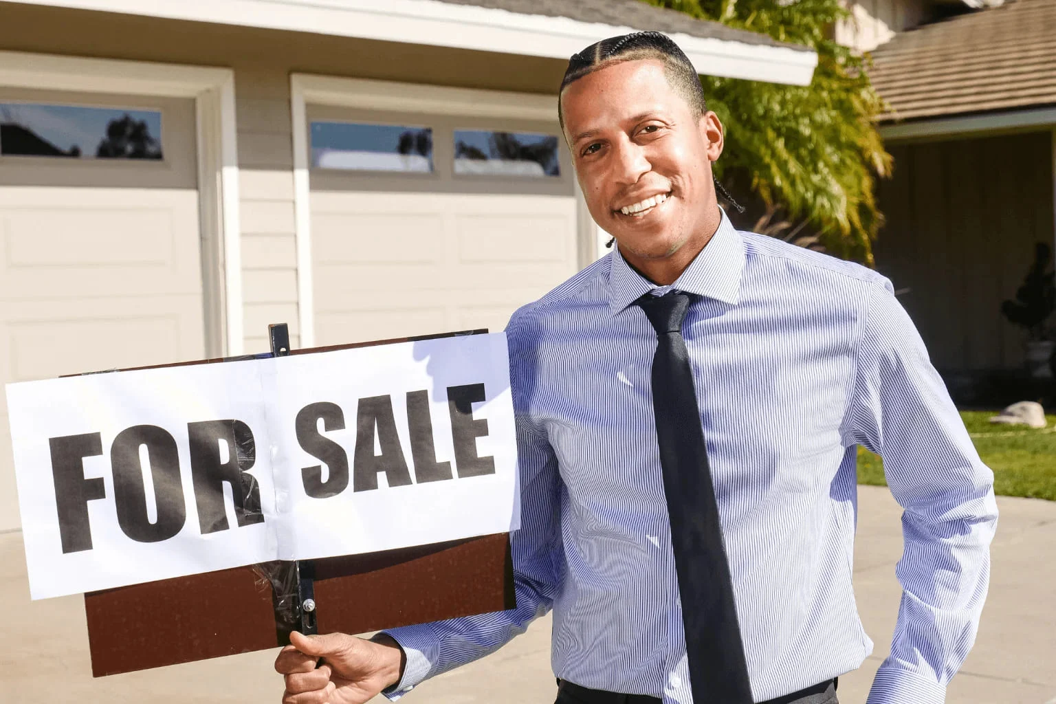 Pleasanton Realtor Realtor putting up a for sale sign in front of a house